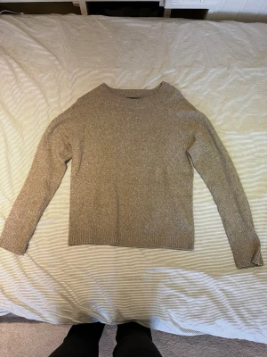 Beige stickad tröja - En beige stickad tröja med rund hals och långa ärmar. Tröjan har ribbade muddar vid ärmslut och nederkant. Från Vero Moda.