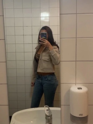 Blå raka jeans med hög midja - Säljer ett par klassiska blå jeans med rak passform och hög midja. Jeansen har fem fickor och stängs med dragkedja och knapp. Perfekta för en trendig och avslappnad look.