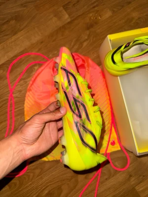 Adidas Fotbollsskor Gul/Rosa F50 Hyperfast Evo FG Storlek 41 1/3 - Säljer ett par Adidas F50 Hyperfast Evo i storlek 41 1/3.  Skorna är använda vid några få träningar men är fortfarande i mycket fint skick. Inga större märken eller skador, och dobbarna är i bra skick. Perfekta för dig som vill ha ett par lätta och snabba fotbollsskor till ett bra pris.  Storlek: 41 1/3 Skick: Mycket fint skick som nytt , sparsamt använda Modell: Adidas F50 Hyperfast Evo FG  Skickas väl emballerade eller hämtas enligt överenskommelse.  Har du frågor eller vill se fler bilder är 