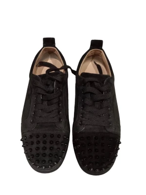 Christian Louboutin, Svarta sneakers med nitar  - Säljer ett par svarta sneakers från Christian Louboutin i mocka med coola svarta nitar på tån. Skorna har klassisk låg profil, svarta skosnören och en stilren design som sticker ut. Perfekta för dig som vill ha något edgy och exklusivt i garderoben.
