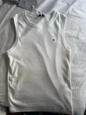 Vit linnetopp från Tommy Hilfiger - Säljer en Tommy hilfiger topp som jag ej använt och prislapp är fortfarande kvar! Jätte fin och går att diskutera pris.