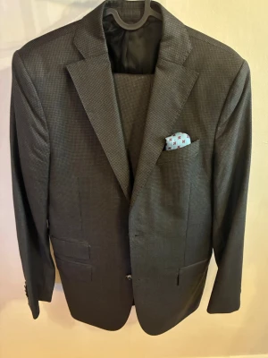 J.Lindeberg x Loro Piana kostym - Snygg mörkgrå kostym med klassisk kavaj och matchande byxor. Kavajen är size 46R och byxorna 48 slim fit. Använd någon enstaka gång men är i väldigt fint skick. Modell på bilderna är 182cm och väger ca 75kg. Skulle säga att kostymen passar som en smäck på någon som är mellan S och M i storlek. 