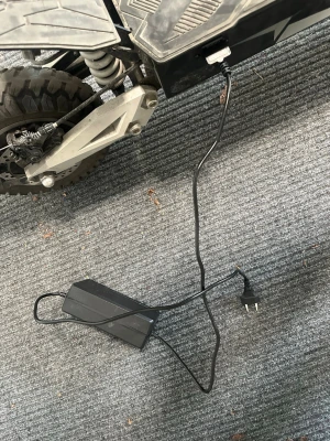 Svart elscooter med laddare - Säljer en svart elscooter med grova däck och medföljande laddare. Scootern har robust ram, fjädring bak och kraftig belysning framtill. Perfekt för dig som vill ta dig fram snabbt och smidigt i stan eller på grusvägar.