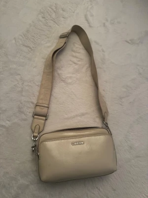 Calvin Klein crossbody bag - Beige Calvin Klein väska. Går ihop till dem flesta stilarna. Använd några gånger. 
