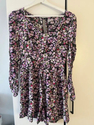 Blommig kortklänning med långa ärmar - Kortklänning/shorts inbyggd att det kan vara skönt när man cyklar så slipper man visa utan det är shorts men ser ut som en klänning väldigt fint mörkt inte ens att det är shorts🩷