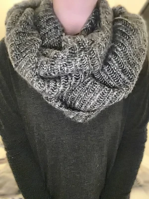 Grå stickad tubhalsduk från H&M - Mysig gråmelerad stickad tubhalsduk från H&M i one size. Halsduken har ett chunky ribbstickat mönster och är gjord i mjukt, värmande material som passar perfekt för kalla dagar. Enkel att slänga över huvudet och ger en avslappnad, trendig look.