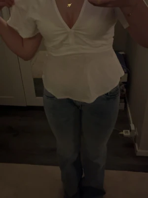 Vit omlottopp med knyt i midjan - Säljer en söt vit omlottopp med v-ringning och korta ärmar. Toppen har ett knytband i midjan som ger en snygg detalj, man kan knyta fram eller bak precis hur man vill. PRIS KAN DISKUTERAS!💞