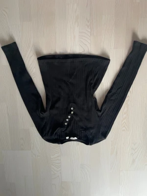 Tröja - Svart ribbad tröja med några knappar längs upp, stretchigt material och sött mönster! Lite Elena Gilbert stil. 🖤Köpt på VeroModa