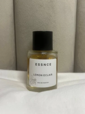 ESSNCE Lemon Eclair Eau de Parfum - Säljer min Lemon Éclaire från Essence som var mycket populär då den kom ut och säljs tyvärr inte längre💛 En söt och fräsch gourmand-doft med tydliga toner av citron och krämig vanilj – perfekt om du gillar lätta, dessertinspirerade parfymer.  Flaskan är lite använd (se bild för nivå), men det finns gott om produkt kvar.   Perfekt för dig som vill ha en unik doft som inte längre går att få tag på! Skriv gärna vid frågor💌