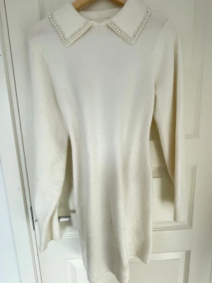 Vit stickad klänning med pärlor - DISCUSS PRICE Knitted dress (knee length) from H&M. Pearls in perfect shape and no sign of distress on material!  Never used. 