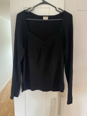 Svart ribbad stickad tröja Stories - Säljer en svart ribbad stickad tröja från Stories i storlek XL. Tröjan har lång ärm, djup urringning och en figurnära passform. Perfekt till höst och vinter för en stilren look. Liten i storleken sitter som en M/L. Tveka inte på att höra av dig om du har några frågor💕 gå gärna in på min profil och kolla!💗
