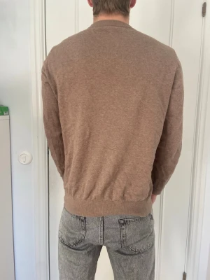 Brun basic tröja i mjukt material - En enkel brun tröja med rund hals och långa ärmar från hm. Använd ett fåtal gånger Normal i storleken