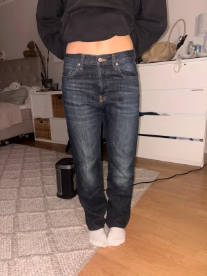 Mörkblå raka jeans - Säljer ett par mörkblå jeans med raka ben och klassisk femficksdesign. Jeansen har kontrastsömmar. Perfekta till en avslappnad stil och passar till det mesta i garderoben.