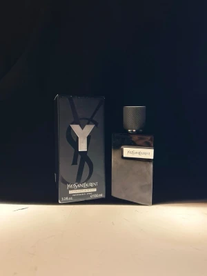 Yves Saint Laurent Y EdP 100ml - Yves Saint Laurent Y Eau de Parfum i 100 ml flaska. Parfymen kommer i en stilren, mörkgrå glasflaska med metallisk etikett och svart texturerad kork. Förpackningen är svart med stor Y-logga och elegant design. Perfekt för dig som gillar exklusiva dofter.