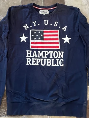 Marinblå Hampton Republic tröja och Nike tröja  - Snygg marinblå sweatshirt från Hampton Republic med tryck av amerikanska flaggan och texten N.Y.U.S.A. Tröjan har rund hals, långa ärmar och ribbade muddar. Perfekt för en sportig och avslappnad look.   150:- st