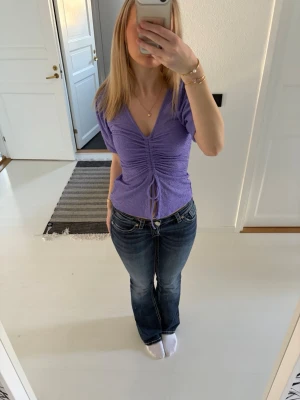 Lila blus från Bikbok💜 - Trendig ljuslila topp med omlott-look och snörning framtill. Toppen har v-ringning, korta ärmar och en croppad passform som ger en modern siluett. Perfekt att styla med jeans eller kjol för en cool vardagslook.                                                                       Aldrig använd och i bra skick! 