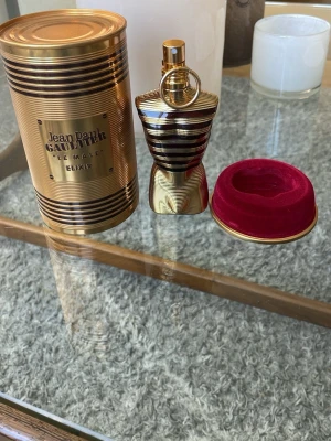 Jean Paul Gaultier Le Male Elixir - 75ml flaska . 50ml kvar.                                          Jean Paul Gaultier Le Male Elixir parfym i en ikonisk guld- och svart randig metallflaska formad som en manlig torso. Kommer med en matchande guldfärgad metallburk och röd sammetsinredning. Lyxig och elegant design som sticker ut i badrumshyllan.