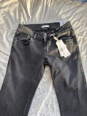 Grå raka jeans från Ginatricot  - Säljer ett par helt nya grå jeans från Ginatricot med fickor på rumpan. Jeansen har dubbla knappar i midjan. Nypris 500 kr. Storlek 38 tall🩷