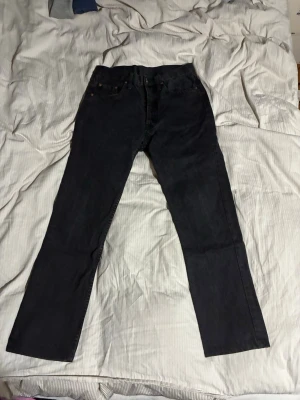 Levis jeans - Säljer ett par svarta jeans från Levi's med klassisk rak passform och fem fickor äldre modell. Tror att det är 501or och dom sitter typ som 29 i midjan och 30 i längd.