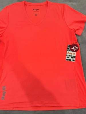 Röd tränings-tshirt Stay Fit XL - Snygg röd tränings-tshirt från Stay Fit i storlek XL. T-shirten har V-ringning och är gjord i ett lätt och snabbtorkande funktionsmaterial, perfekt för gymmet eller löprundan. Diskret logga nere vid fållen och klassisk passform.