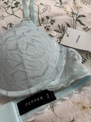 Ljusblå spets-bh från Pepper - Bh från pepper som jag tyvärr beställde i fel storlek. Helt ny, limited edition och finns inte i Sverige (köpt med tullavgifter), därav priset. Vacker turkos färg med shimmerdetaljer🩵Jag rekommenderar att följa storleksguiden på wearpepper.com oavsett om du vet din storlek sedan innan. Det är väldigt bra kvalitet och super bekväm. Modell: All over lace lift up bra- metallic crystal Storlek: 34A