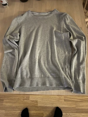 Två basic tröjor i grått och marinblått - Säljer två stilrena tröjor i basic modell, en i ljusgrått och en i marinblått. Båda har rund halsringning, långa ärmar och ribbade muddar vid ärmslut och nederkant. Skick 10/10, aldrig använda! Storlek medium. Köp båda tröjorna för 249kr eller 150kr/st