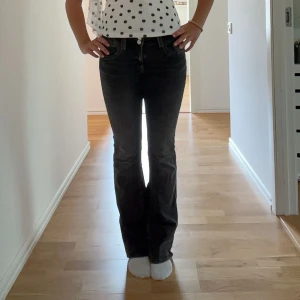Svarta/Gråa bootcut jeans från Gina Young  - Säljer ett par svarta/gråa bootcut jeans med låg midja och klassiska fem fickor. Jeansen har en snygg passform med bootcut design. Perfekta för dig som gillar en trendig och clean look. 💛Byxorna sitter bra på mig som är 168cm! 💛 Köpta för 349. 