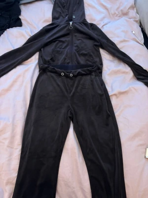 Svart velourset från Gina Tricot - Mysigt svart loungewear-set i velour från Gina Tricot. Setet består av en hoodie med dragkedja och huva samt matchande byxor med resår och dragsko i midjan. Perfekt för chill dagar hemma eller när du vill vara extra bekväm.