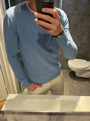 Ljusblå rundhalsad tröja - Snygg ljusblå tröja med rund halsringning från Bruun stengade. Tröjan passar perfekt till vår och sommar. Jag på bilden bär storlek S och är 188cm. Hör av er vid funderingar eller prisförslag:)