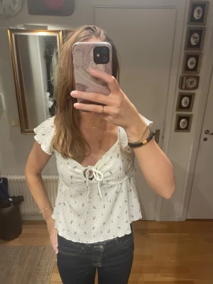 Peplumtopp  - Söt vit peplumtopp med små blommor och knyt framtill✨