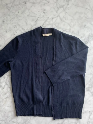 Mörkblå kofta - Mörkblå kofta med trekvartsärm. Jättemjukt material. Fin detalj längs med längderna framtill. Endast använd ett fåtal gånger.