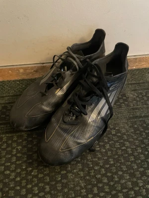 Adidas F50 - Använda skor som fortfarande har liv i sig. Ett par mindre skador finns. Endast skorna som medföljer