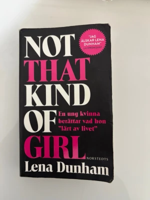 Not That Kind of Girl av Lena Dunham - En svart pocketbok med titeln 'Not That Kind of Girl' av Lena Dunham. Boken handlar om en ung kvinnas erfarenheter av livet, vänskap och kärlek. Perfekt för dig som gillar personliga berättelser och humor. Har spillts vatten i boken som lämnat märken som man ser på bilden, 
