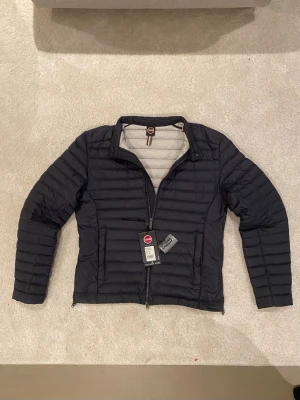 Marinblå vårjacka från Colmar - Säljer nu min marinblå pufferjacka från Colmar då den blivit för liten 💪 Jackan är i näst intill nyskick, taggen och extraknappar följer med 🤩 (taggarna sitter inte kvar). Quiltad design, diskret logga på ärmen, två sidofickor med dragkedja och en ljusgrå insida. 