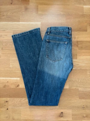 Blå bootcut jeans - Säljer ett par klassiska blå bootcut jeans med en klassisk fem fickor look. Jeansen har lite lägre midja och är tillverkade i denim med en snygg tvätt. Perfekta för en avslappnad och trendig look. Är ca 34cm rätt över och innebenslängden är ca 82 cm❤️ Köpde dessa här på plick, men de var tyvärr för små så måste sälja de❤️Pris kan diskuteras. Skriv gärna innan ni köper.