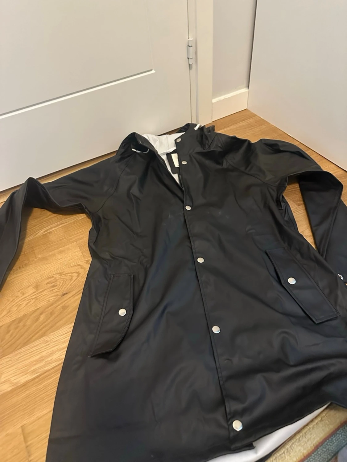 Svart regnjacka med huva