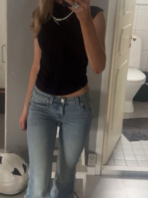 Svart ärmlös topp från Gina Tricot - Snygg svart ärmlös topp från Gina Tricot med rund halsringning. Toppen har en tight passform och är tillverkad i mjuk bomull, perfekt att styla med jeans eller kjol.