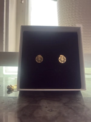 Guldpläterade örhängen med geometriskt mönster - Snygga små örhängen i guldpläterad metall med ett stilrent, geometriskt mönster. Perfekta för dig som gillar minimalistisk och modern design. Kommer i en elegant ask.