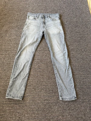 Jeans - 33/36. Snygga ljusgrå jeans från Levi's Premium med klassisk femficksmodell och raka ben. Jeansen har en stilren look och är tillverkade i mjukt denimtyg. Perfekta för dig som gillar en avslappnad men trendig stil.