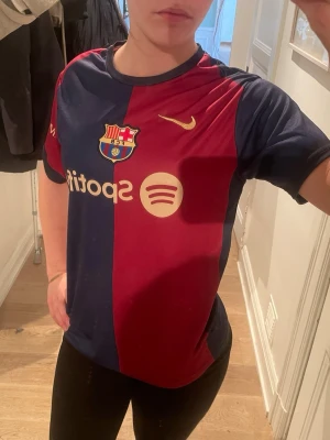 FC barcelona  - Säljer min fotbollströja, den är i nytt skick då jag knappt använt den, det är inte min stil därför säljer jag. Skriv för mer info och bilder💕💕osäker på storlek men den passar alla mina vänner iaf och vi alla är ish Small och Medium. Vissa 163-170 cm långa skulle jag säga 