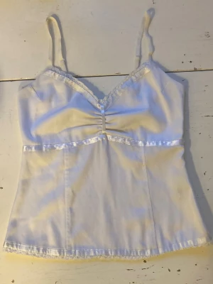 🍒Vintage babydoll linnetopp i satin🍒 - 🍒U ARE LiKE A STAR🍒Så snygg babydoll linnetopp i matt satin med smala reglerbara axelband. Toppen har fina spetsdetaljer, glansiga pärlfärgade band, en smockad rygg och dragkedja i sidan. Missa inte denna!🍒