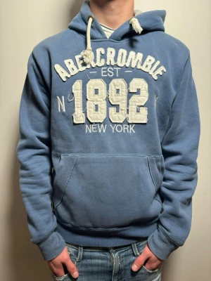 Fet blå hoodie! - Fet blå vintage hoodie. Med ett snygg text som är broderad. Märke Abercrombie & fitch!! Passar perfekt nu till våren! Size M. Skick 9/10. Skriv vid frågor.