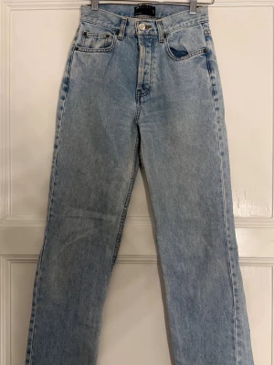 Ljusblå raka jeans från asos - Säljer ett par ljusblå jeans från asos med rak passform och hög midja. Klassisk femficksmodell i slitstark denim med knappgylf och bälteshällor. Perfekta för en avslappnad och trendig look.
