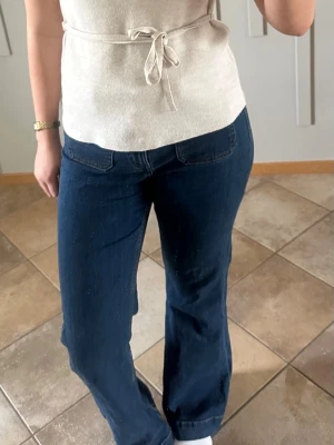 Blå bootcut jeans med hög midja från bikbok - Snygga blå jeans med bootcut-modell och hög midja. Jeansen har framfickor med dekorativa sömmar och stängs med knapp och dragkedja. Perfekta för en trendig och avslappnad look. Materialet är klassisk denim i bomull. strl 31/34 passar dig med M skulle jag säga!❤️