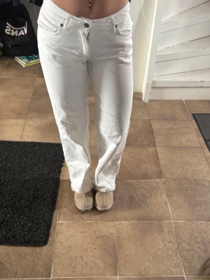 Vita raka jeans - Säljer ett par vita jeans med rak passform och låg midja. Jeansen har klassiska fem fickor och stängs med knapp och dragkedja. Perfekta för en clean och fräsch look. Materialet är denim i bomull. Passar perfekt till sommaren och våren, använda fåtal gånger men säljer då dem är för små💕
