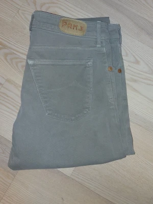 Jacob cohën Limited edition nick 1633 - Snygga grå jeans från PRMJ med raka ben och klassisk femficksmodell. Jeansen har knappgylf och detaljer i kopparfärg vid fickorna. Tillverkade i ett slitstarkt bomullsmaterial som ger en skön passform.