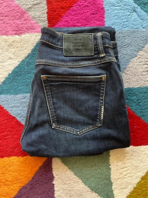 Mörkblå slim fit jeans från Neuw - Säljer ett par mörkblå Nuew Jeans Lou Slim med klassisk femficksdesign och kontrastsömmar. Jeansen är tillverkade i slitstark denim och har en snygg, smal passform som sitter riktigt bra. Perfekta för dig som gillar stilrena och tidlösa jeans. Priser är ej hugget i sten och tveka inte på att höra av dig vid funderingar! Storlek 30/32! Nypriset ligger på runt 1500!
