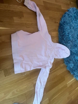 Ljusrosa hoodie från Race Marine - Säljer en ljusrosa hoodie från Race Marine med svart tryck på bröstet. Hoodien har en klassisk känguruficka framtill och en huva. Tillverkad i mjukt bomullsmaterial, perfekt för chill dagar. Snygg och enkel design som passar till det mesta.