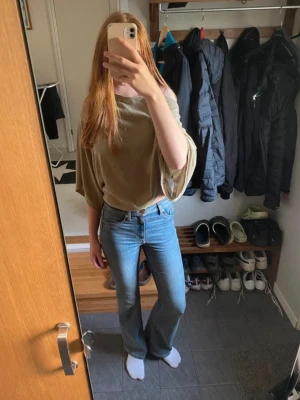 Blå bootcut jeans med hög midja - Säljer ett par klassiska blå bootcut jeans med hög midja. Jeansen har bälteshällor och är perfekta för en avslappnad och trendig look. Materialet är denim i bomull och passformen är smickrande och bekväm.