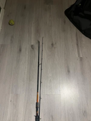 Kinetic Trigger multirullespö 2-delat - Säljer ett kinetic Trigger multirullespö, 2-delat och 2,25 meter långt. Kastvikt 25-70g, svart med orange detaljer. Perfekt för gäddfiske eller andra större rovfiskar. Utrustad med flera spöringar och triggerhandtag för bättre grepp.